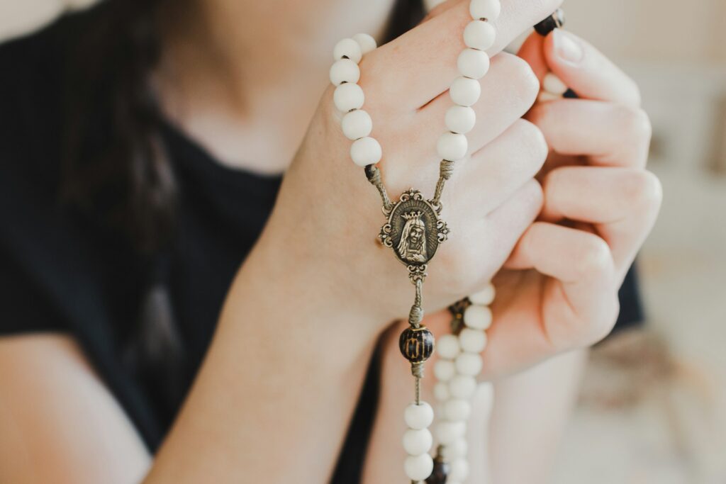 A woman holding rosary beads.