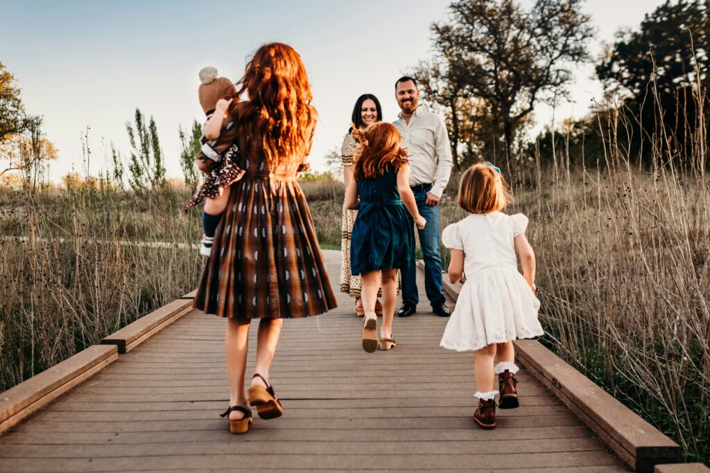 Children walking towards their parents along a boardwalk