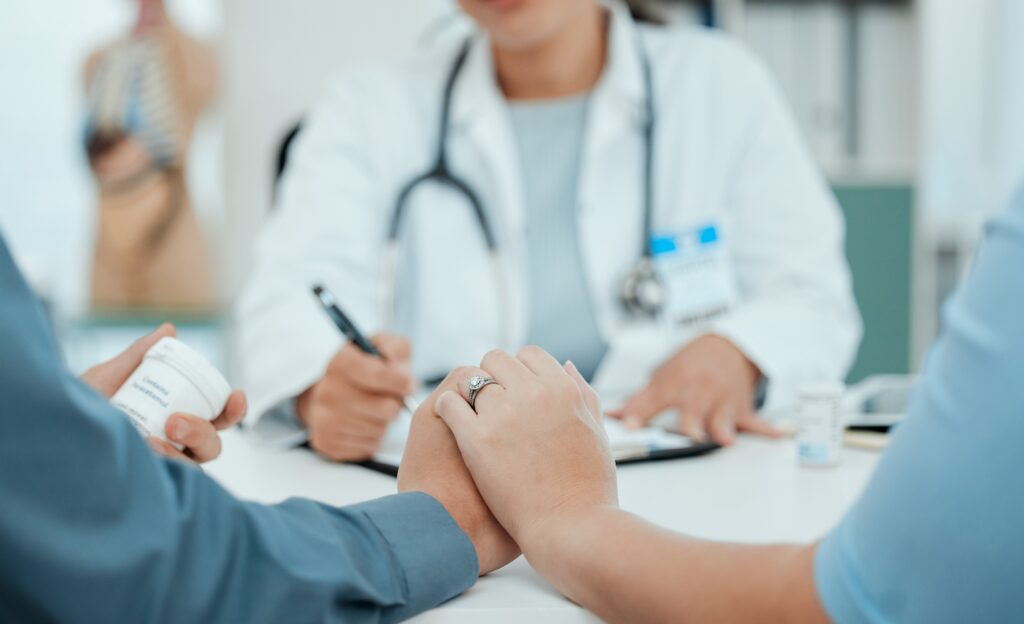A couple holding hands in a fertility clinic.
