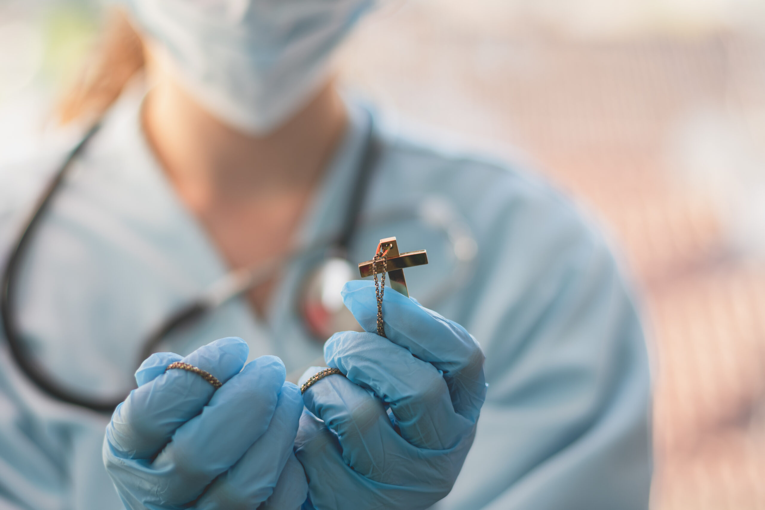 Female doctor holding a crucifix.